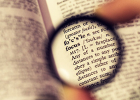 A page from a dictionary. The page is blurry, except for the section seen through a lens. That section is clear, and centered on the word “focus” 