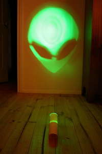 image of a green alien skull with two large black eyes and a pointed chin being projected onto a wall