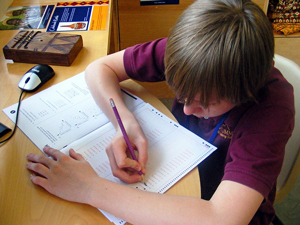 A photograph of a male student working on a test booklet