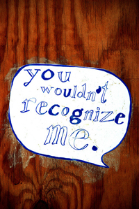 A photograph of a sign on a door that reads “You wouldn't recognize me.”