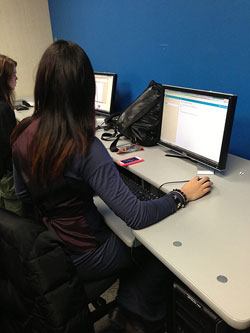 Image of girl sitting in front of computer screen.