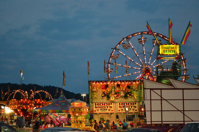A picture of carnival rides and games at night. 
