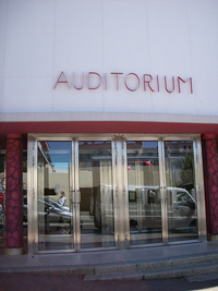 A photograph of the outside of an auditorium where the word 'auditorium' is above the door