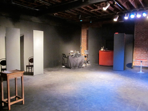 A photograph of an empty stage with some props visible on the edges of the stage