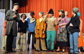 A photograph of a school production of My Fair Lady during rehearsals; There are ten teenagers on stage.