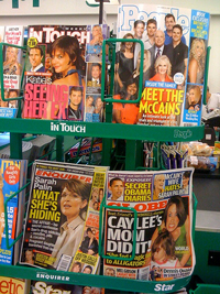 A magazine rack of tabloid publications.