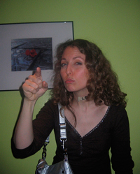 A photograph of a woman pointing with her index finger in a scolding fashion