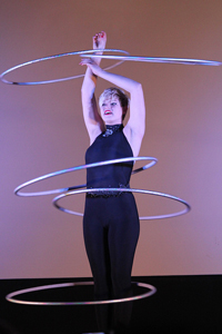 A photo of a performer twirling five hula-hoops