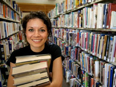 woman standing between shelves in a library