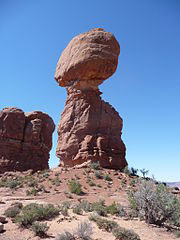 Image is of a large boulder balanced on another large boulder