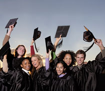 Image of four girls and two males dressed in graduation gowns and holding their graduation