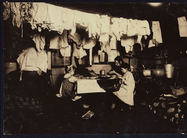 Image of a mother and her daughters sitting at the table in a dark room 