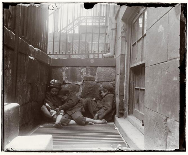 This is an image of three boys sleeping in an alley.