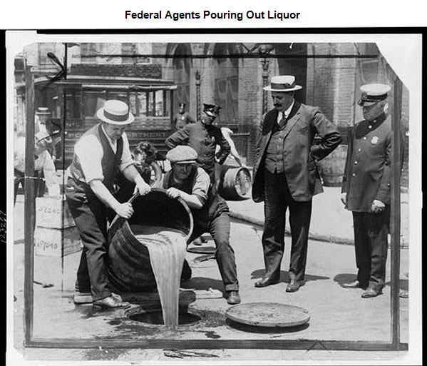 Image of a two men pouring out a barrel of alcohol while two officials watch