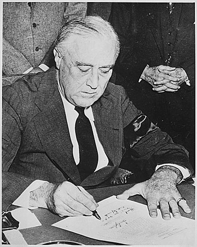 Image of Franklin Delano Roosevelt signing the declaration of war