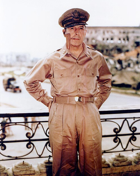 Image of General Douglas MacArthur dressed in his military uniform and smoking a corncob pipe.