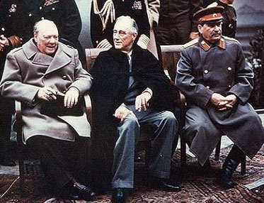 A photo of Winston Churchill, Franklin Roosevelt, and Joseph Stalin sitting on a bench surrounded by military officers at the Yalta Conference in the Ukraine.