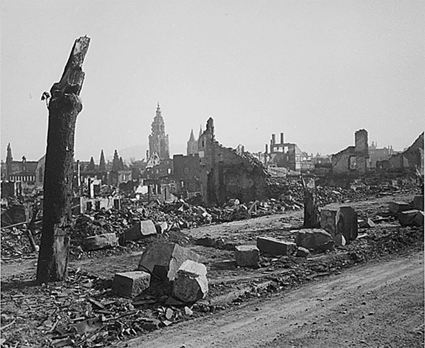 A photograph of Heilbronn, Germany sometime after an intense bombing campaign by the allies. The streets are strewn with debris, the trees are burned to stumps, and most of the buildings are reduced to partial frames and walls.