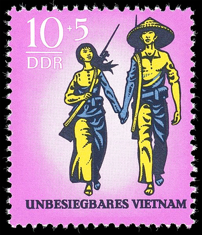 A stamp showing Vietnamese Guerillas, a man and woman holding hands, walking triumphantly