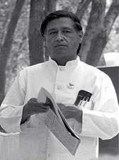 a photograph of Mexican American civil rights leader, Cesar Chavez, holding a newspaper.