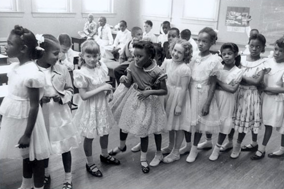 A photograph of elementary aged school children in a newly integrated classroom.