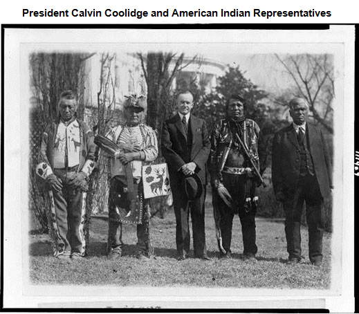 Image of President Calvin Coolidge standing on the lawn of the White House. He is flanked by American men on both sides