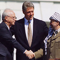 Image of Yitzhak Rabin and Yasser Arafat shaking hands with Bill Clinton in the Background