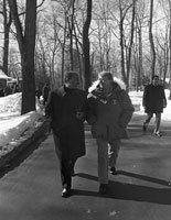 Image of Sadat and Carter walking along a trail at Camp David, both are dressed in overcoats