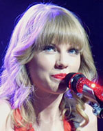 Image of Taylor Swift standing in front of a microphone.